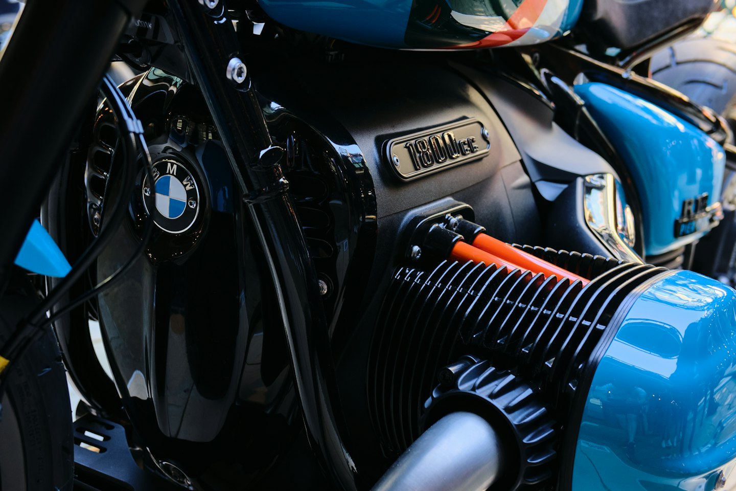 Primer plano de un motor de motocicleta con detalles en azul y cables naranjas.