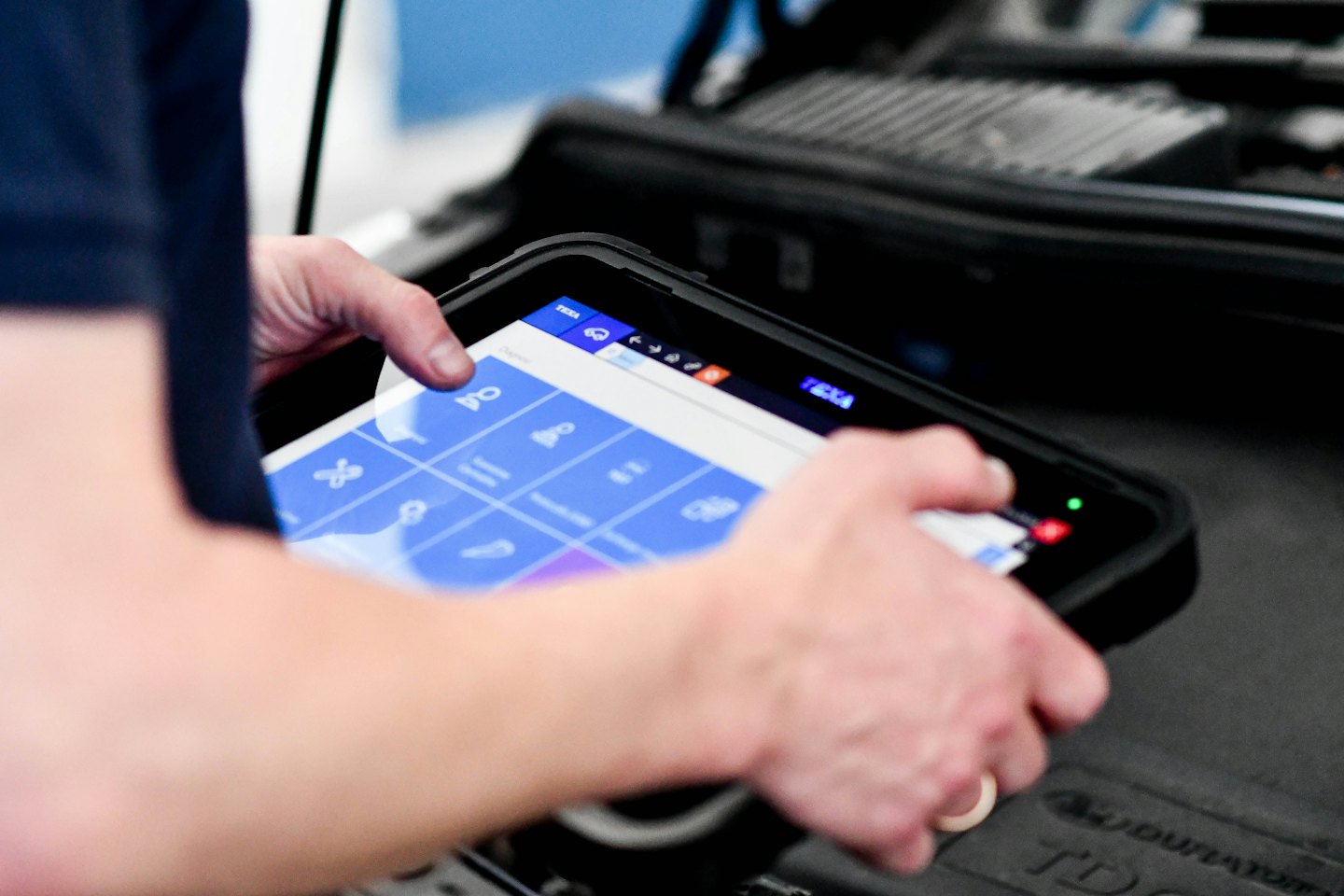 Un técnico usa una tableta para diagnosticar un motor.