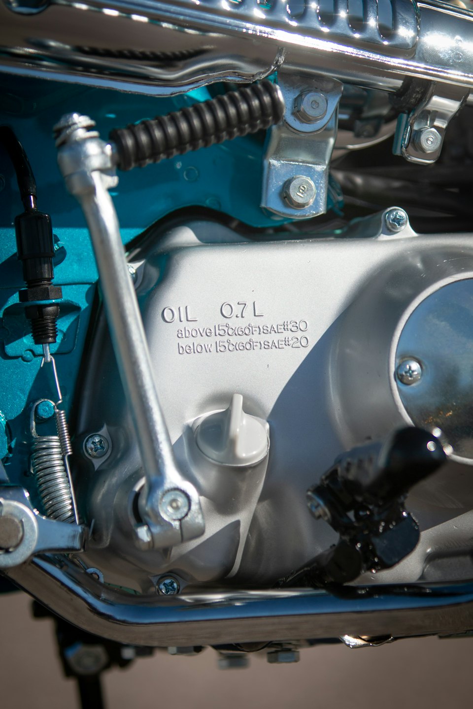 Primer plano de un motor de motocicleta con un marco turquesa.