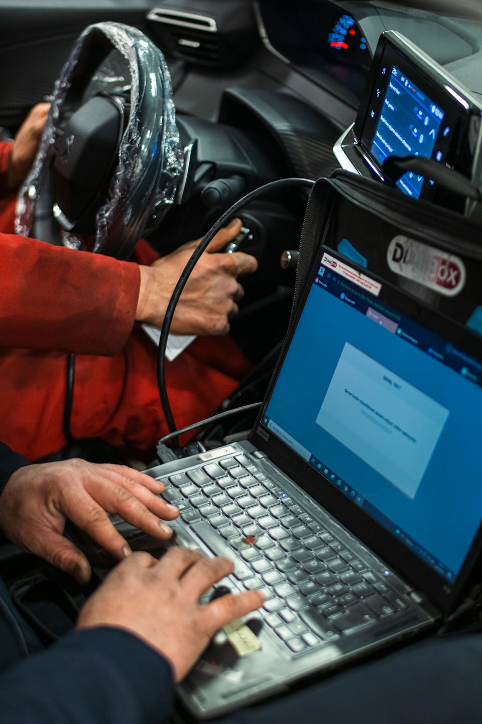 Mecánicos realizan diagnósticos en la cabina de un coche.